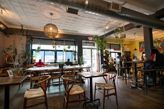 a restaurant filled with lots of wooden tables and chairs