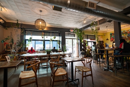a restaurant filled with lots of wooden tables and chairs