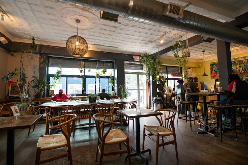 a restaurant filled with lots of wooden tables and chairs