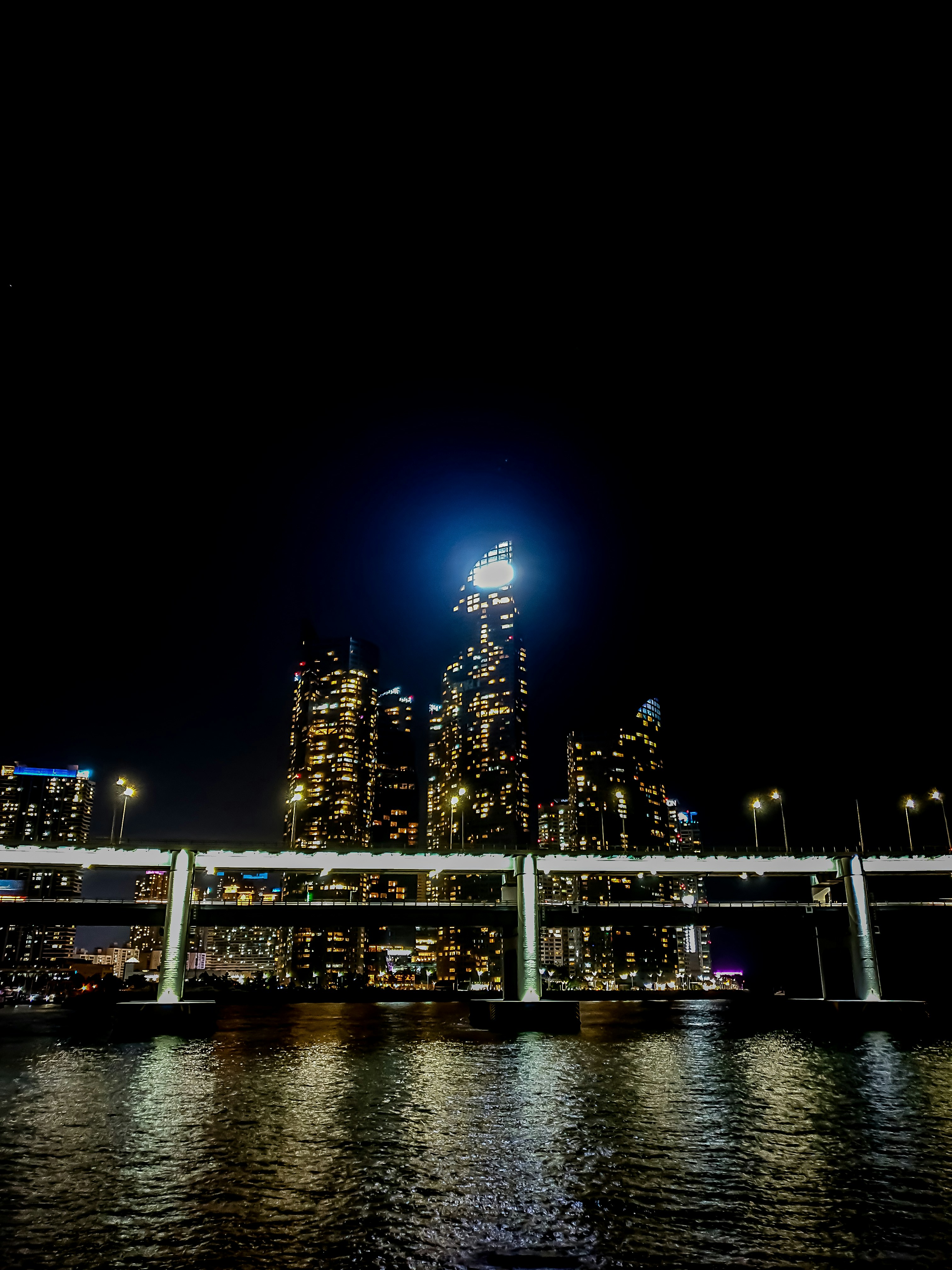a bridge over a body of water with a city in the background