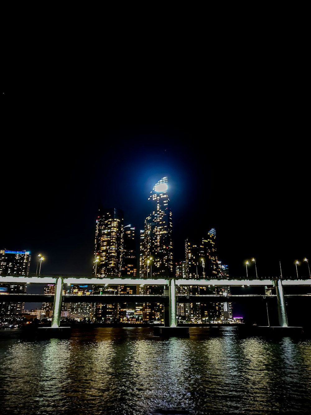 a bridge over a body of water with a city in the background