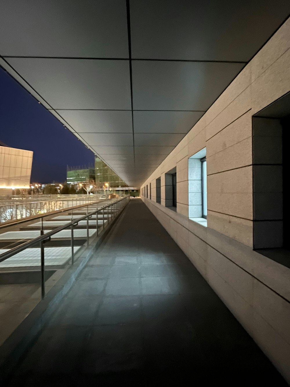 an empty walkway with a building in the background