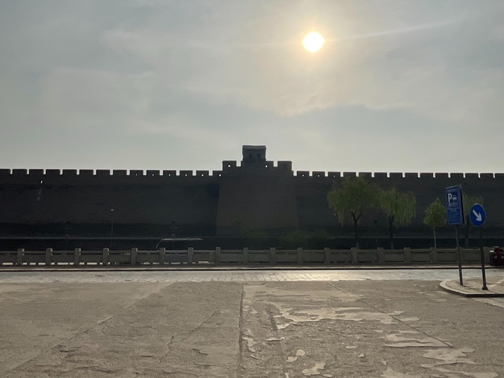 an empty parking lot with a large wall in the background