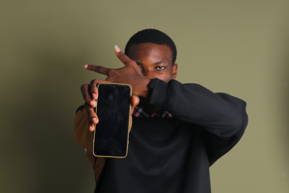 a man holding up a cell phone in front of his face