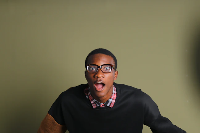 A screenshot of a prank video showing a surprised reaction in a green and blue themed room.