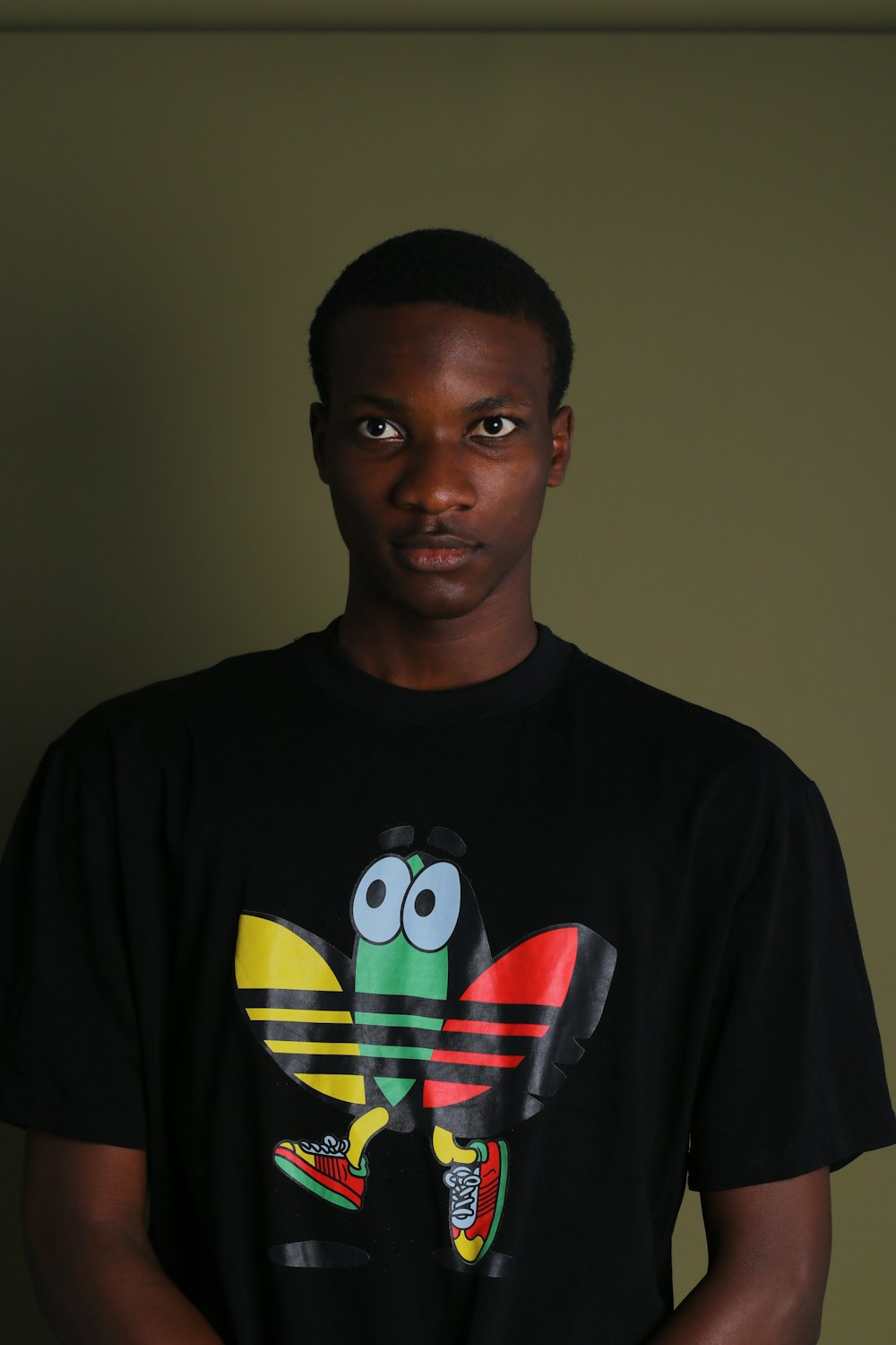 a man wearing a black shirt with a colorful bird on it