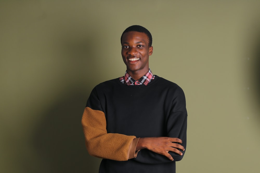 a man standing in front of a green wall