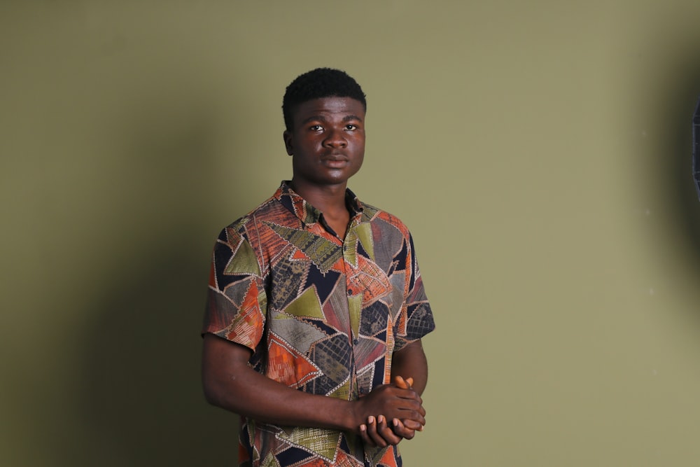 a man standing in front of a green wall