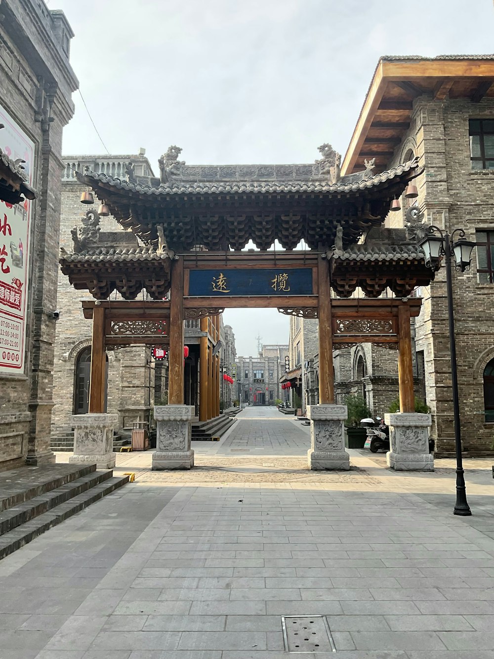 a stone walkway leading to a building with a sign on it