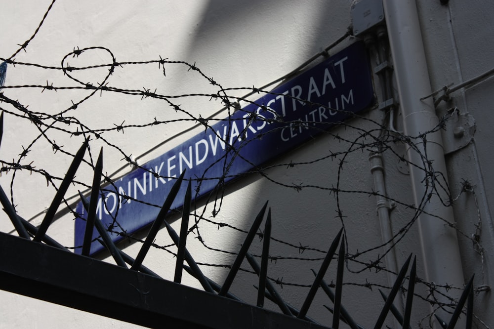 a blue street sign hanging from the side of a building