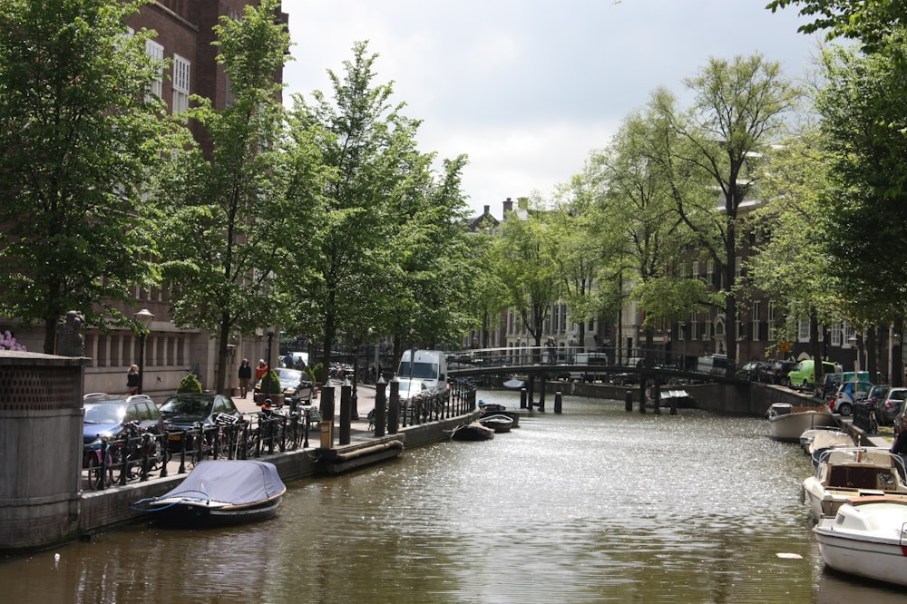 a canal with boats and people walking on it