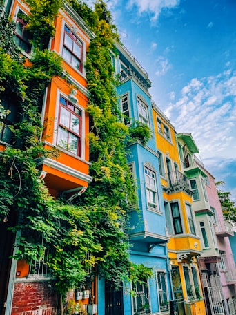a row of multicolored buildings with a blue sky in the background