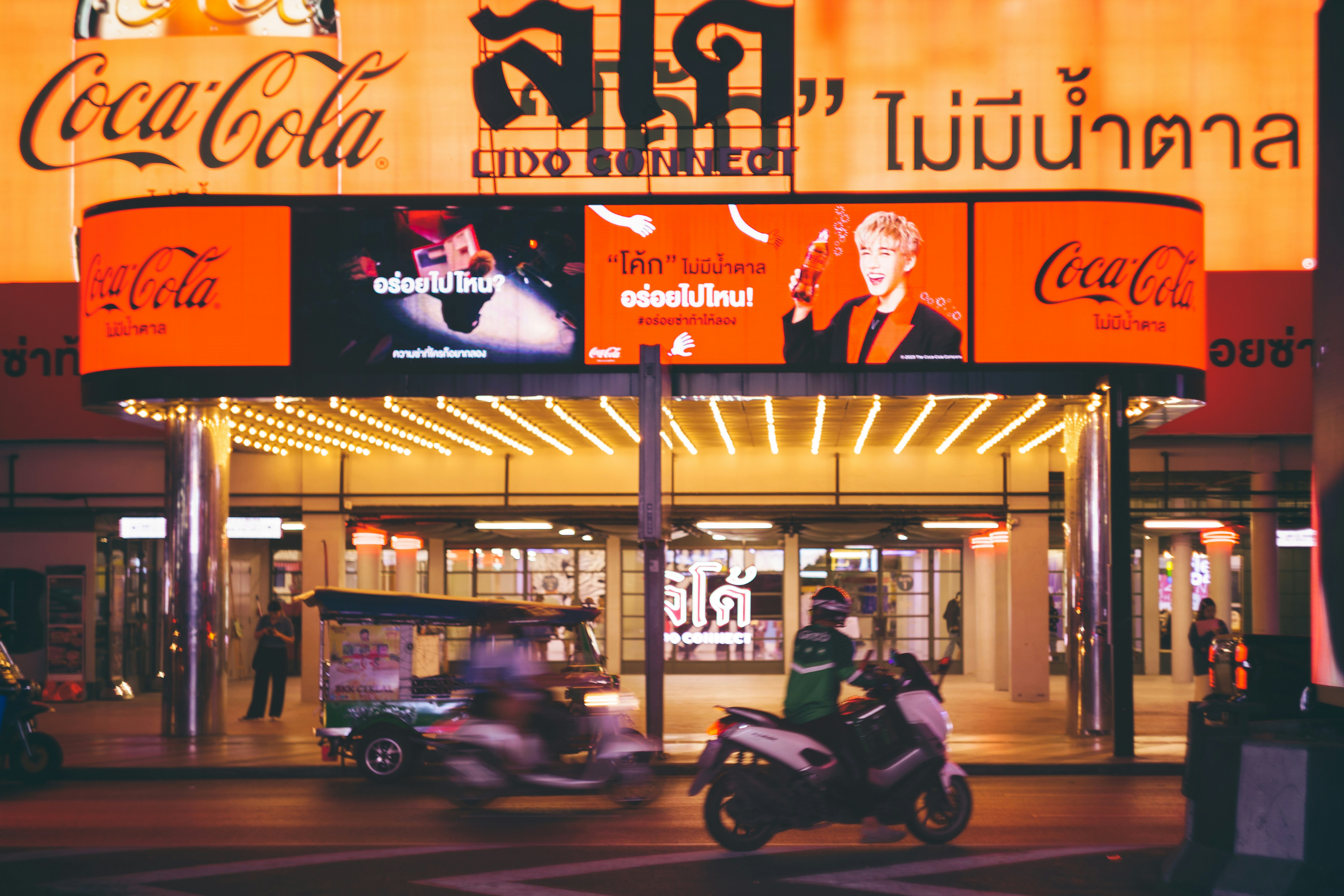 A person on a motor bike in front of a building
