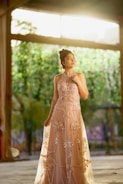 Model wearing a custom-made evening gown in a sunlit room