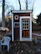 A neatly built wooden wendy house used as a small office space with a window open.