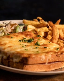 A warm plate featuring a gourmet sandwich with crisp greens and a side of fries.
