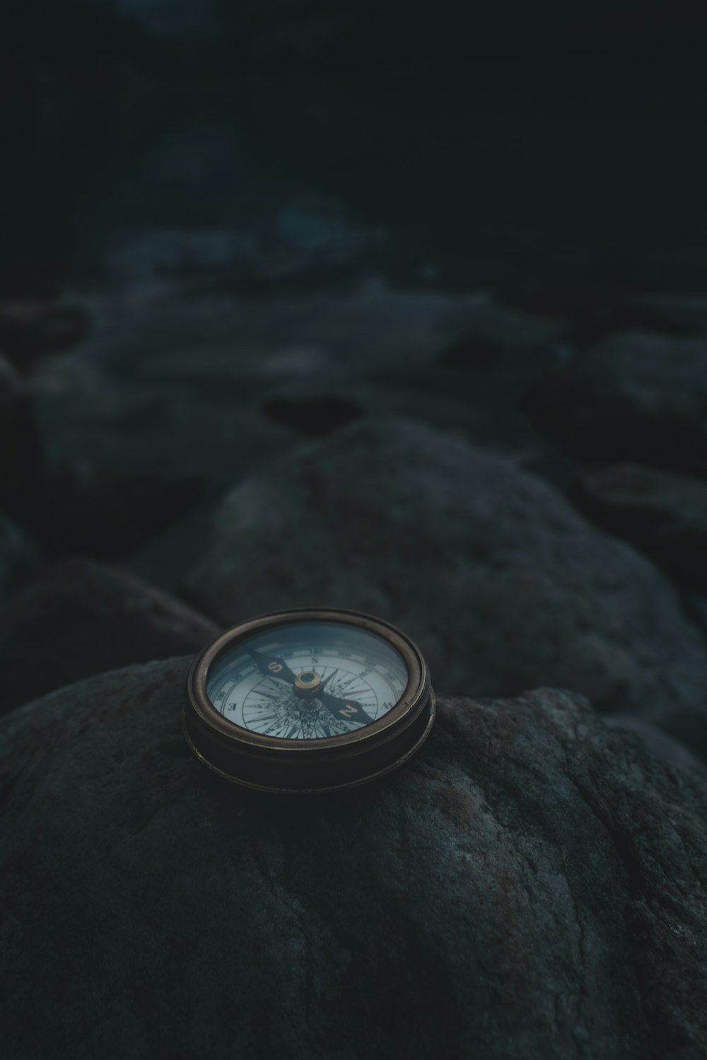 a compass sitting on top of a rock