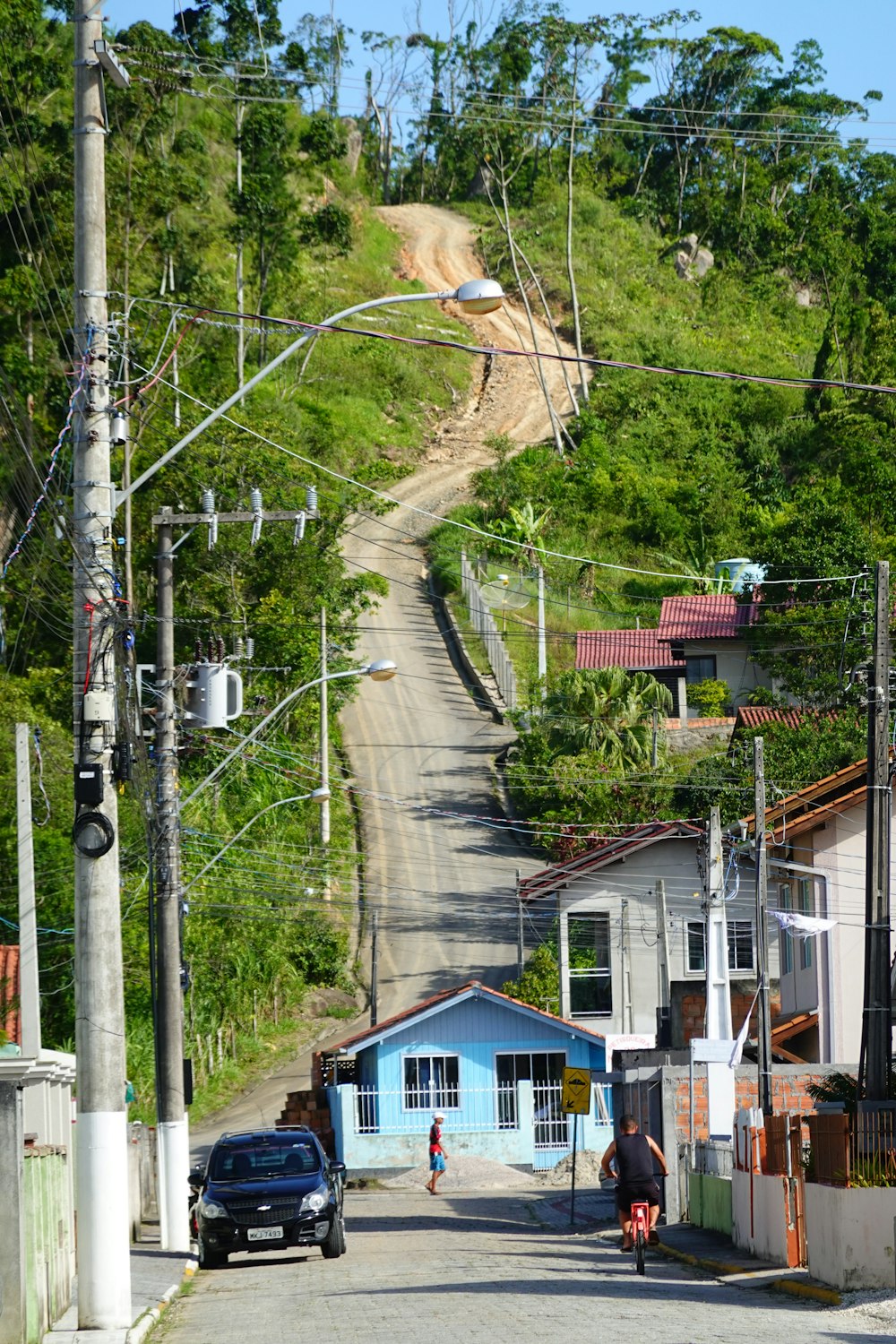 a car driving down a street next to a hill