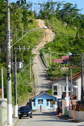 a car driving down a street next to a hill
