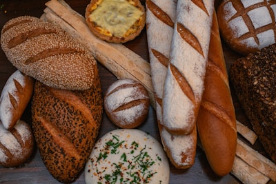 Assortment of artisanal breads and baked goods on a wooden board.