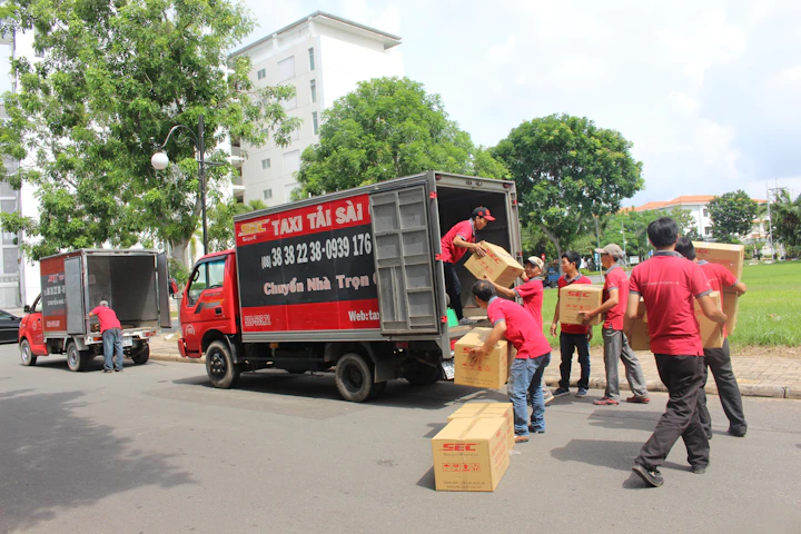 Donlevy team members loading boxes into a delivery truck on a sunny morning.
