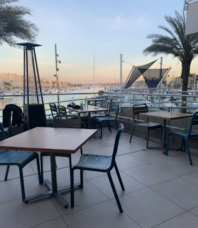 A comfortable seating area aboard a premium yacht, shaded and overlooking the pristine marina.