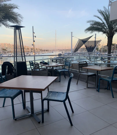A comfortable seating area aboard a premium yacht, shaded and overlooking the pristine marina.