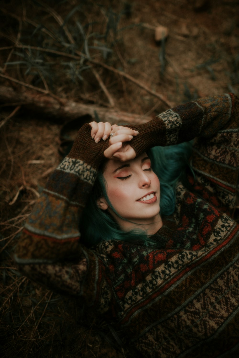 une femme aux cheveux verts allongée sur le sol