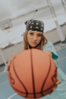 a young woman holding a basketball on a basketball court