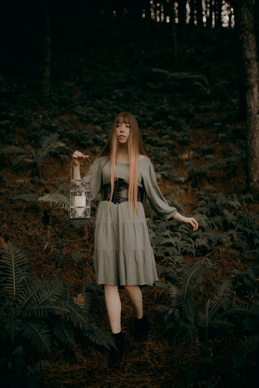 a woman with long hair standing in a forest