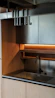 A sleek contemporary modular kitchen with warm wooden finishes and modern appliances.