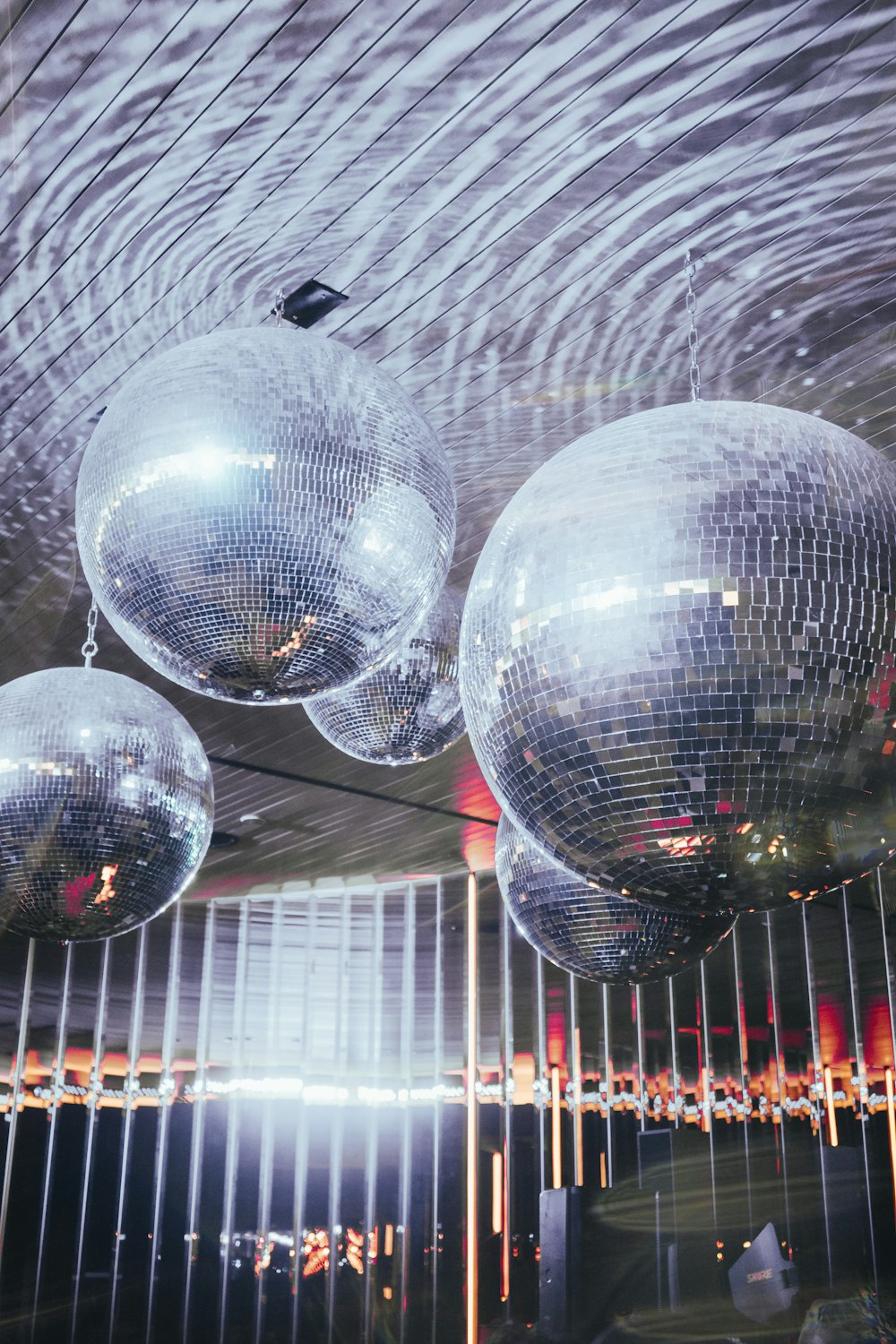 a group of shiny disco balls hanging from a ceiling