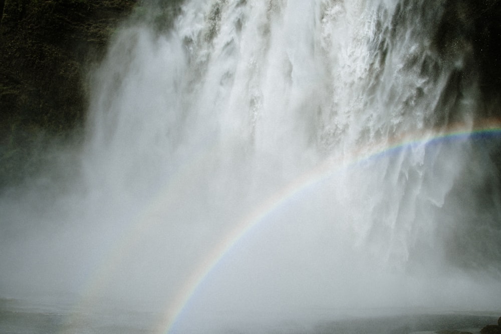 a rainbow in the middle of a waterfall