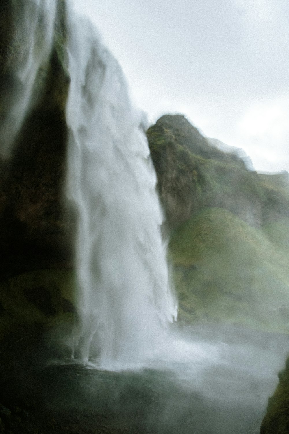 a large waterfall is pouring water into a body of water