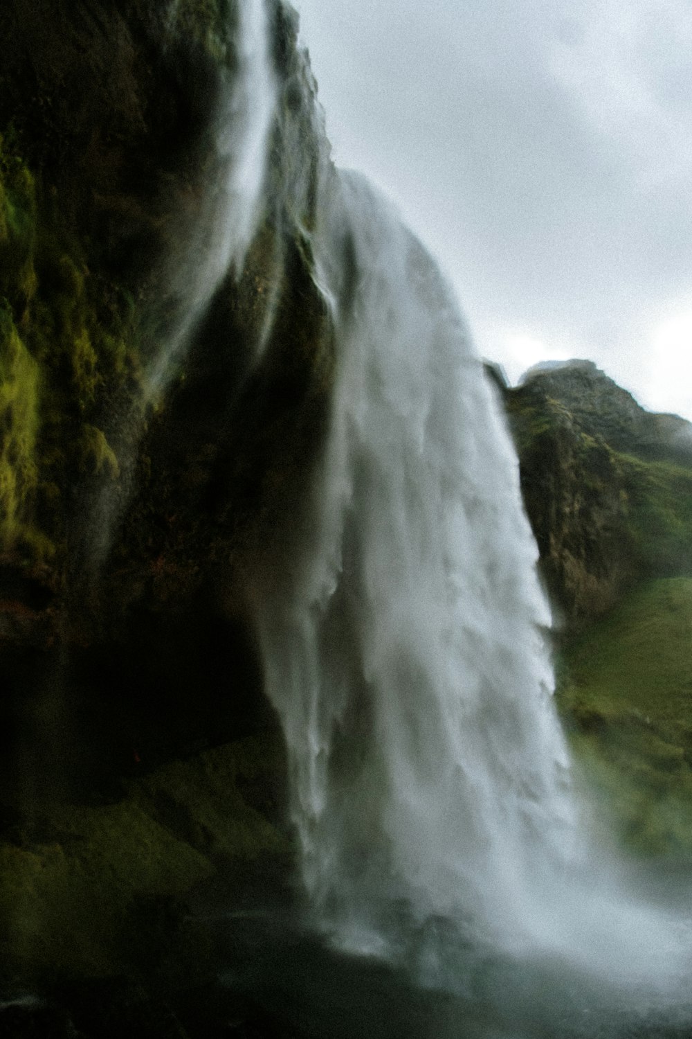 a large waterfall with a man standing in front of it