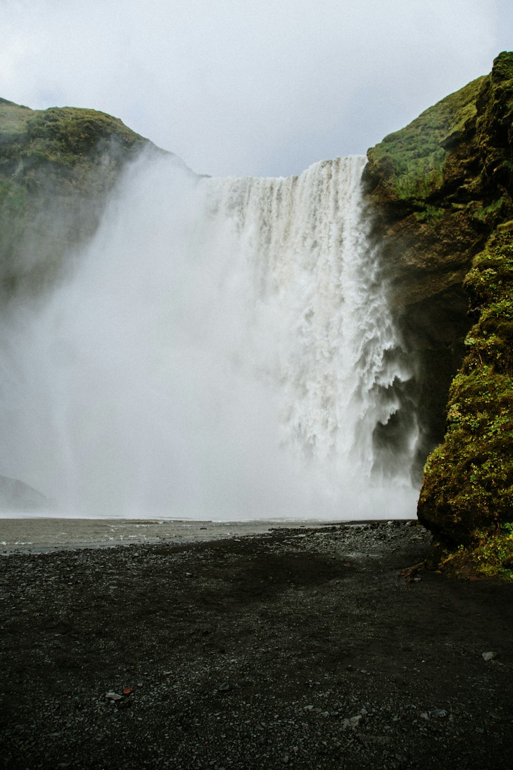 un homme debout devant une cascade