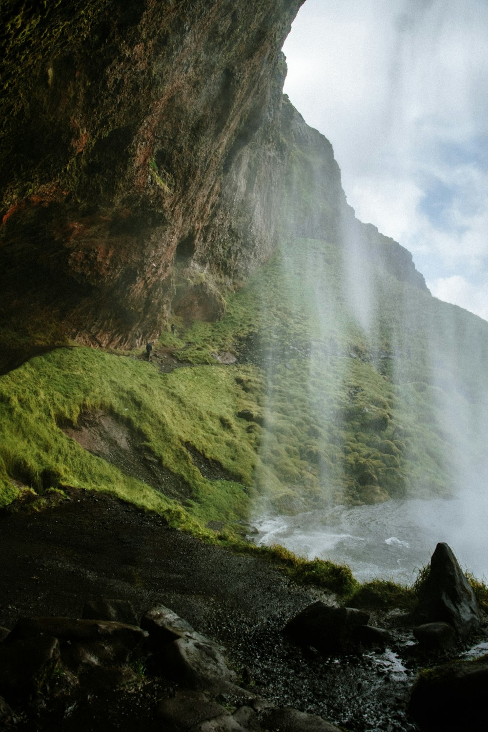 a large waterfall is coming out of the side of a mountain