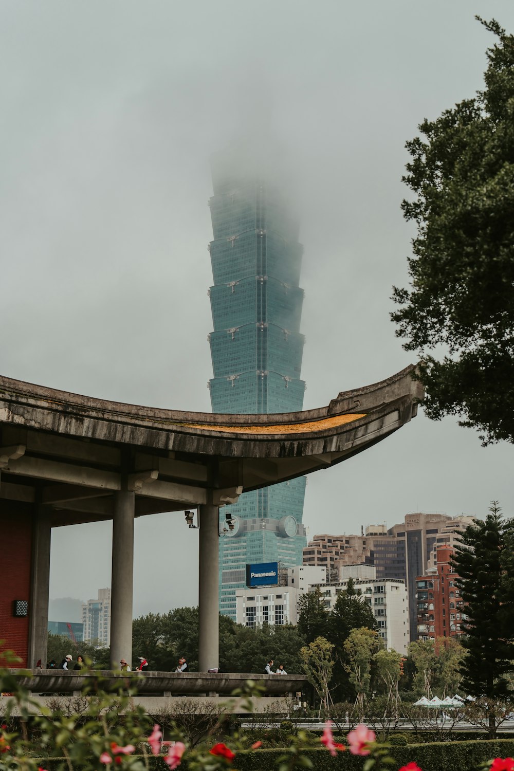 a tall building towering over a city on a cloudy day
