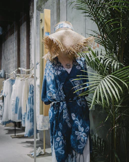 A mannequin dressed in casual clothing standing next to a large ceramic vase.