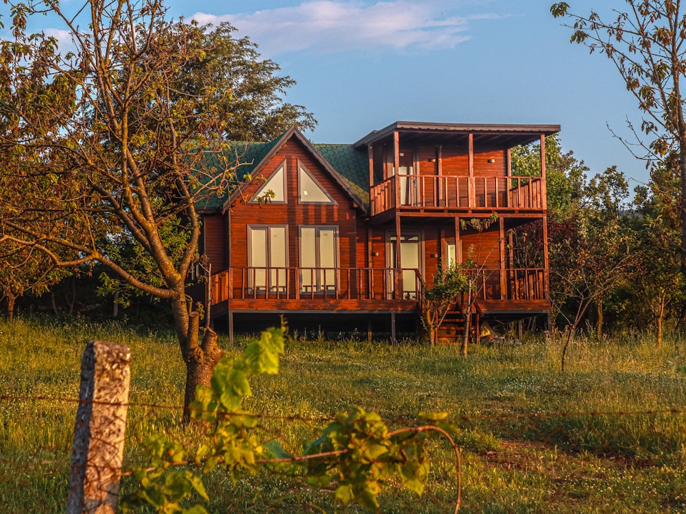 a large wooden house sitting in the middle of a field