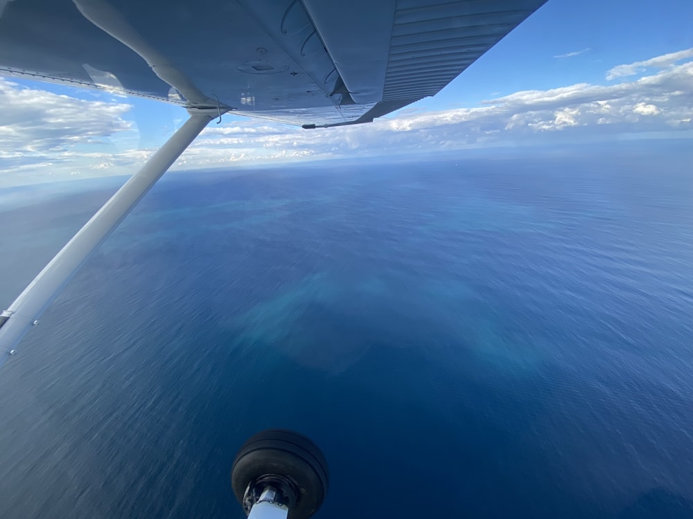 a view of the wing of a plane flying over the ocean