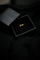 Minimalist display of an open velvet box revealing a delicate bangle under gentle lighting.