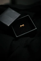 Artful shot of a sleek black jewelry box opening to reveal a shimmering necklace.