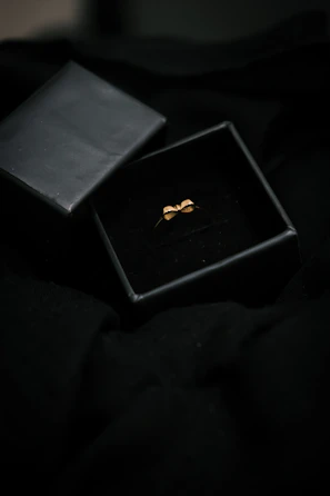 Minimalist display of an open velvet box revealing a delicate bangle under gentle lighting.