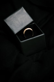 An elegant product shot of handcrafted jewelry with black and gold background highlighting the details.