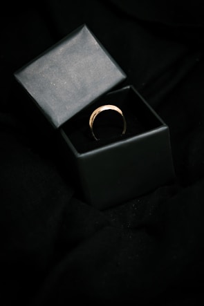 The Orukka VIP ring elegantly worn on a hand against a deep charcoal background, showcasing its minimalist design.
