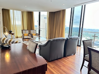 Elegant living room with floor-to-ceiling windows dressed in sleek, custom roller shades.