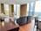 A panoramic view of a modern living room with large windows and stylish furniture.