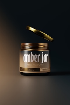 A jar with a metallic dark lid hovers slightly above its container. The jar is labeled 'amber jar' with 'mockup templates' in smaller text underneath. The background is dark with a subtle gradient lighting effect, emphasizing the jar as the focal point.