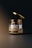 A jar with a metallic dark lid hovers slightly above its container. The jar is labeled 'amber jar' with 'mockup templates' in smaller text underneath. The background is dark with a subtle gradient lighting effect, emphasizing the jar as the focal point.